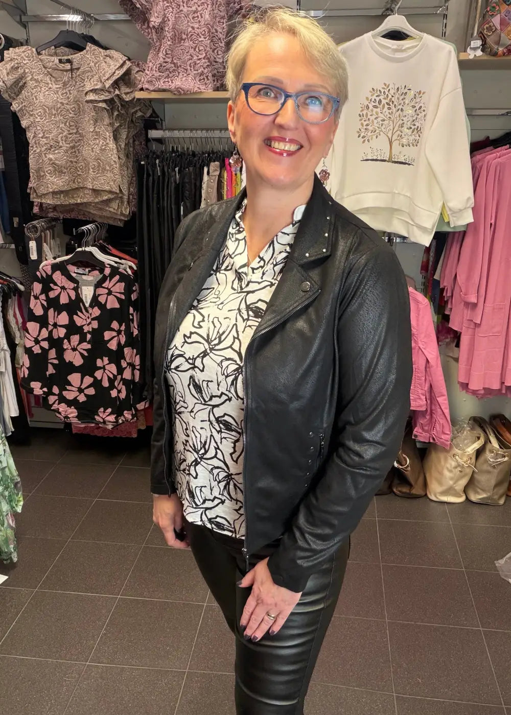 Naisten mustavalkoinen paitapusero joustavasta materiaalista, V-pääntie ja pieni kaulus, vajaamittaiset hihat ja kaareva helma