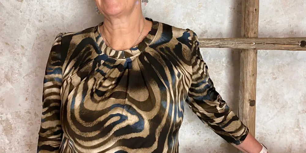 Kuvioitu paita, puhvihihat, O-pääntie, laskokset ja siro nappikiinnitys niskassa.