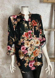 Naisten musta kukkakuvioinen paitapusero, kevyt ja boheemi V-pääntiellä, nappirivillä ja tamppihihoilla.