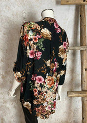 Naisten musta kukkakuvioinen paitapusero, kevyt ja boheemi V-pääntiellä, nappirivillä ja tamppihihoilla.