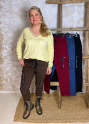 Reisitaskuhousut joustavasta materiaalista, korkea vyötärö leveällä kuminauhalla ja kiristysnauhoilla, kapenevat lahkeet ja edessä taskut