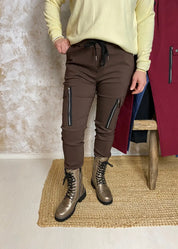 Reisitaskuhousut joustavasta materiaalista, korkea vyötärö leveällä kuminauhalla ja kiristysnauhoilla, kapenevat lahkeet ja edessä taskut