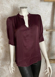 Naisten hehkuva satiinipusero, V-pääntie, puffihihat ja kaareva helma – tyylikäs valinta arkeen ja juhlaan.