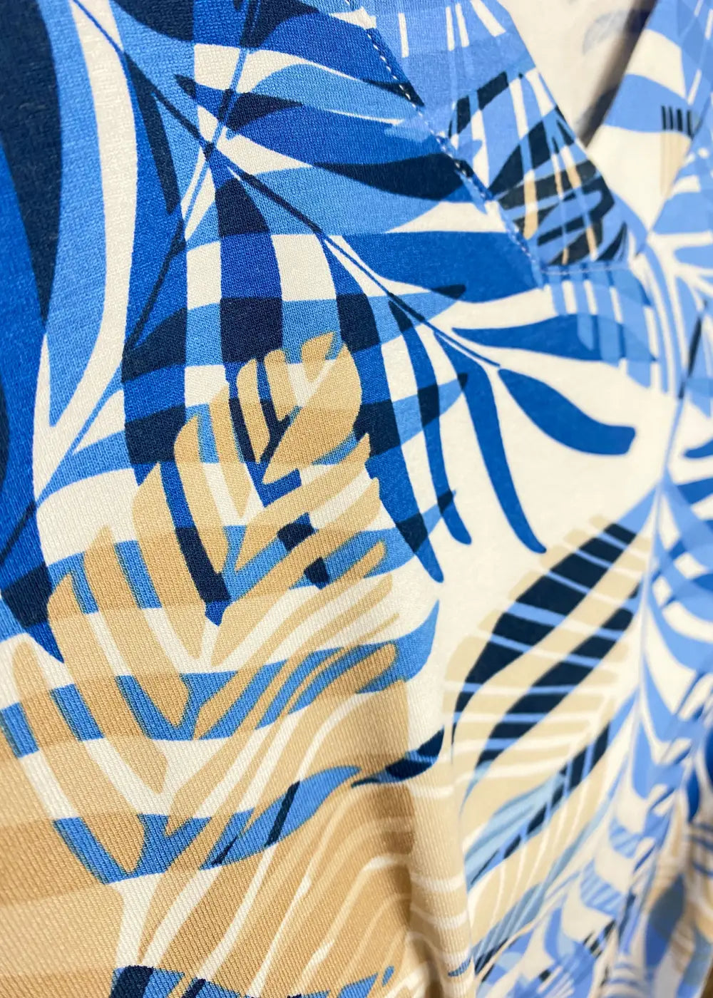 Naisten lyhythihainen tunika sinisävyisellä lehtikuviolla, pehmeä ja joustava materiaali, A-linjainen malli ja V-pääntie